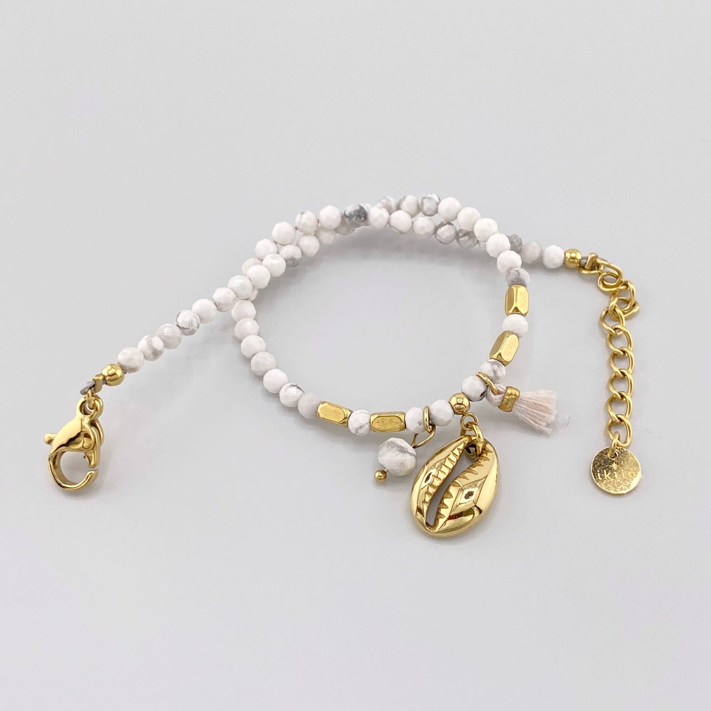 Howlite bracelet with gold-plated elements and a shell-shaped pendant, French brand Ikita.