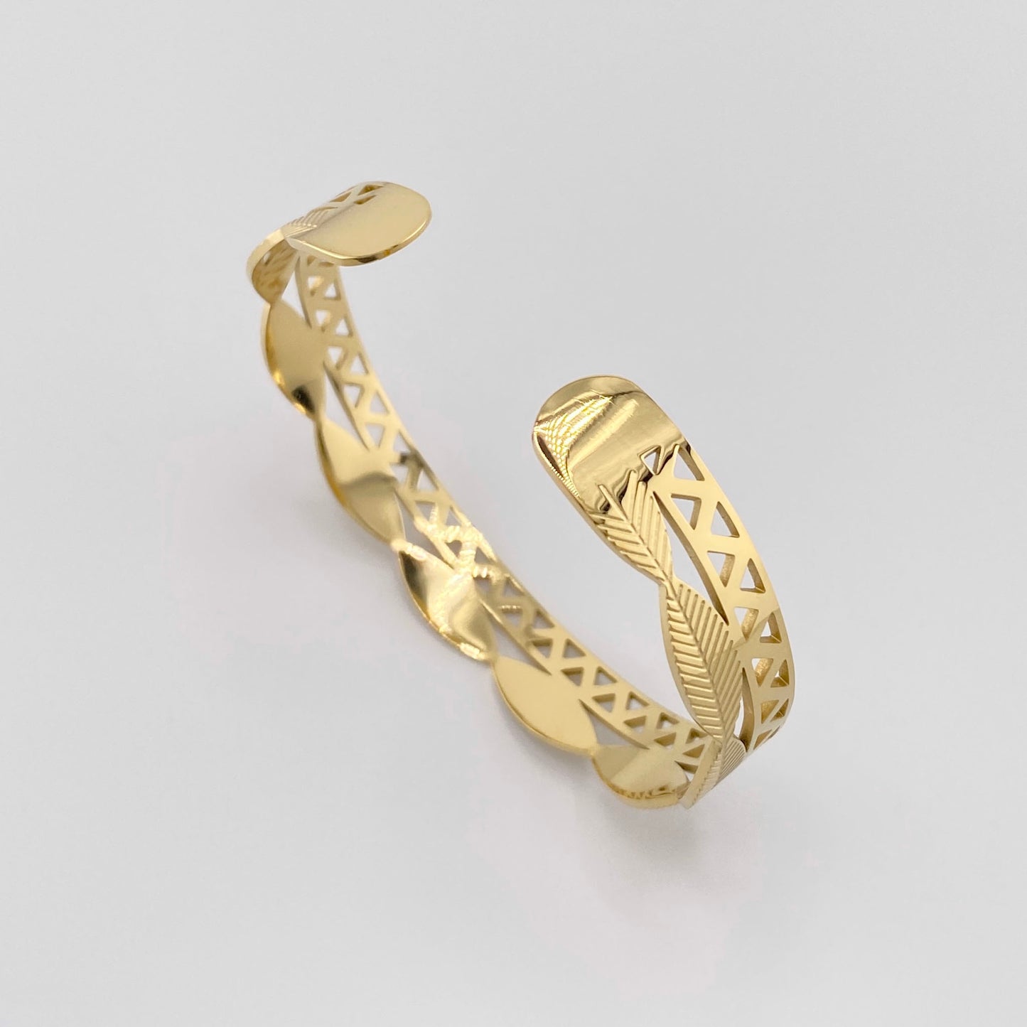 Bracelet doré avec motif de feuilles et design ajouré, marque française Ikita.