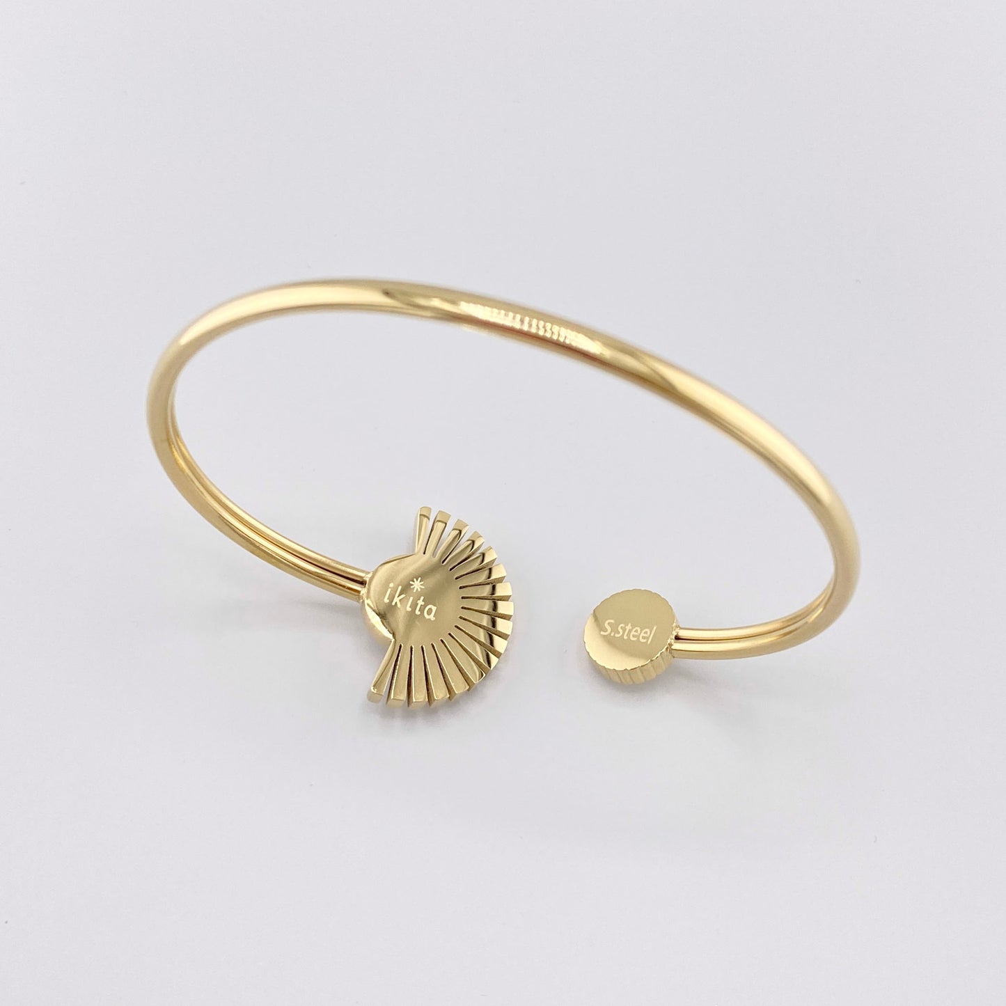 Gold-plated bracelet with a fan-shaped design, adorned with a white crystal and enamel, French brand Ikita.