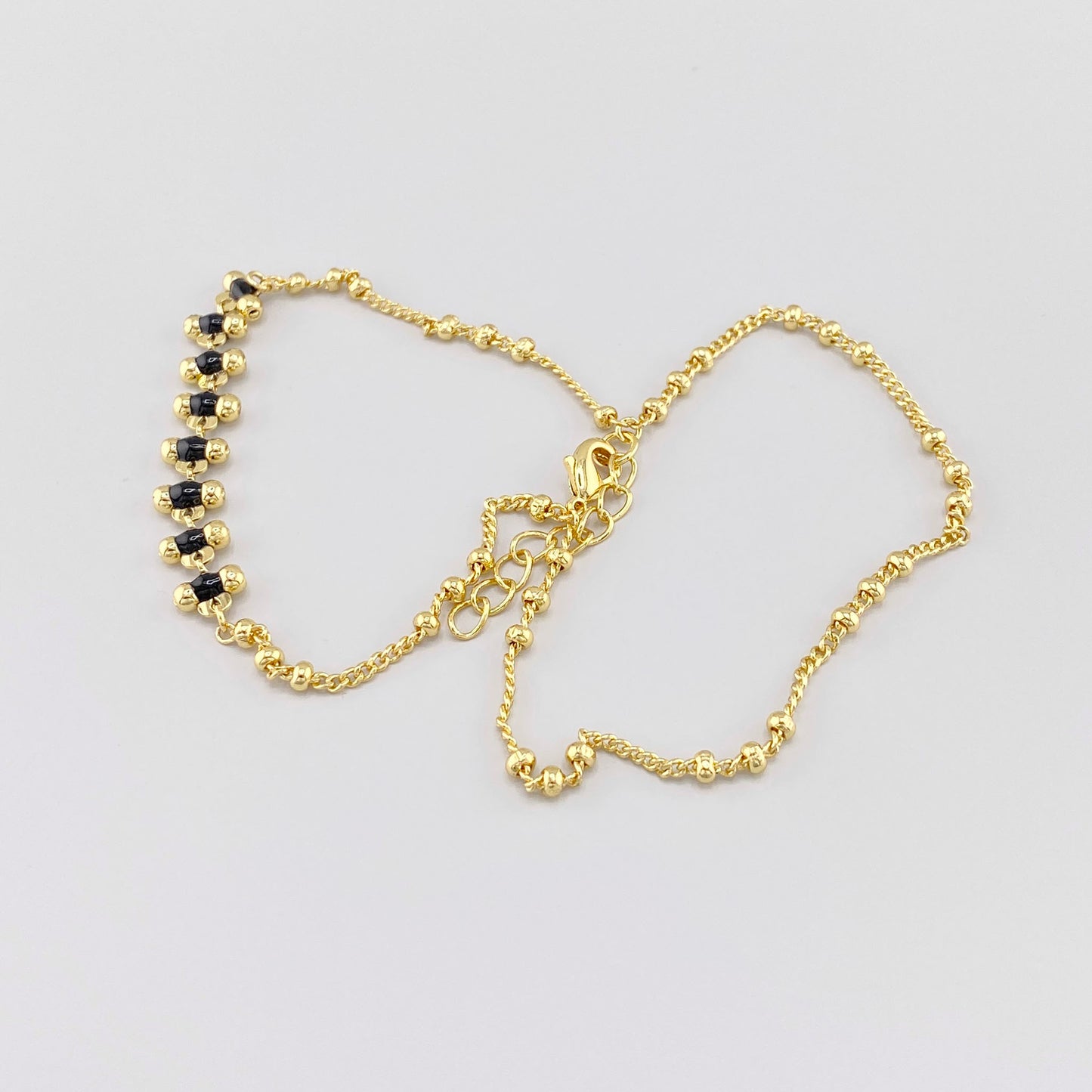 Pulsera de acero dorado con detalles de esmalte negro, marca francesa IRL.