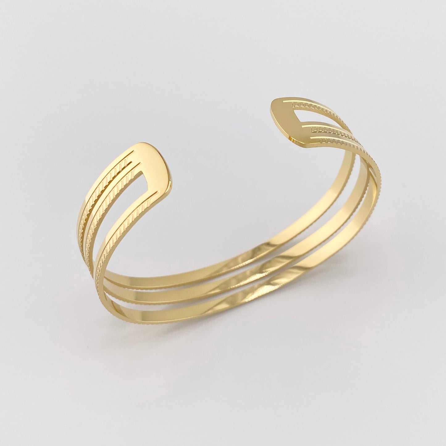 Offenes Armband aus vergoldetem Stahl mit drei schmalen Reifen, französische Marke Ikita.
