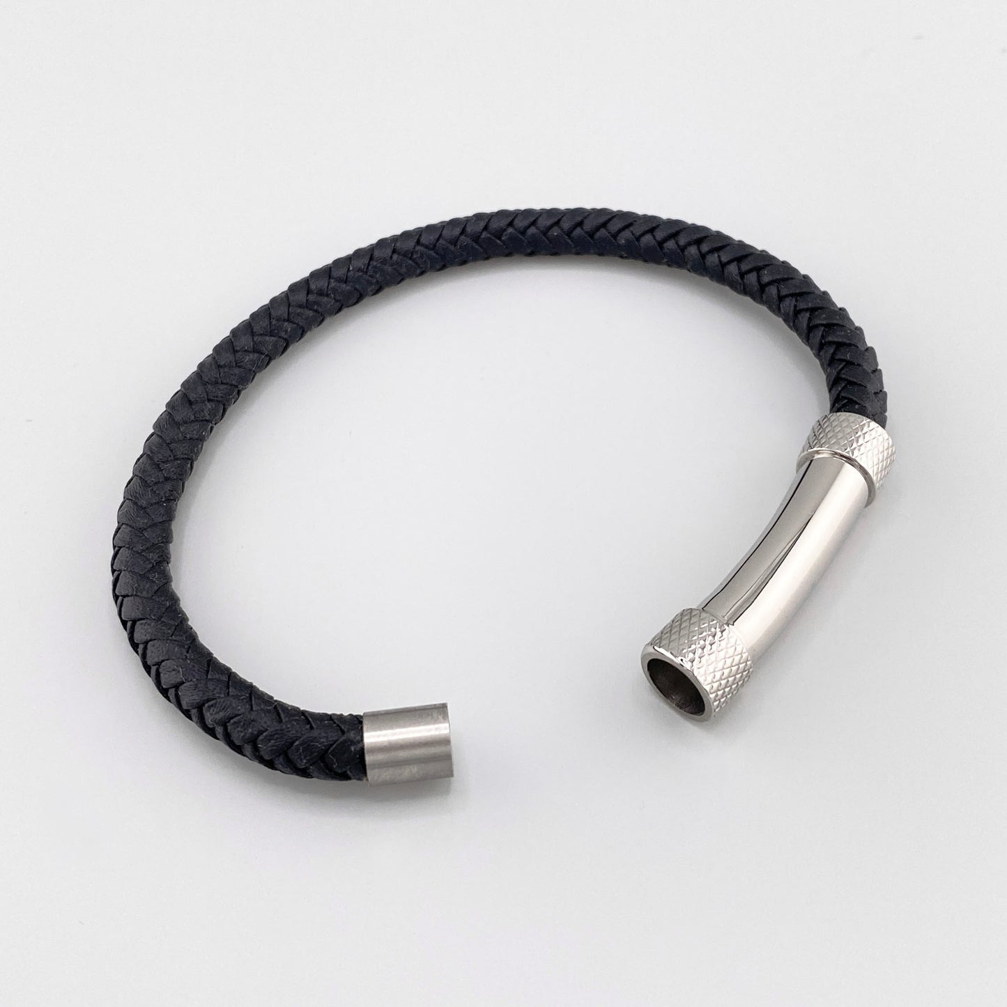 Herrenarmband aus schwarzem geflochtenem Leder mit einem silberfarbenen Edelstahlzylinder und Magnetverschluss, französische Marke IRL.