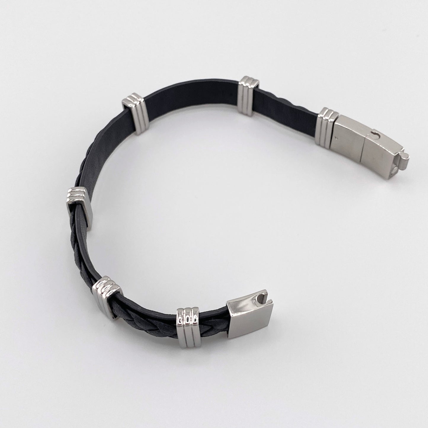 Pulsera de cuero negro trenzado con detalles de acero inoxidable en color plateado y cierre magnético, marca francesa IRL.