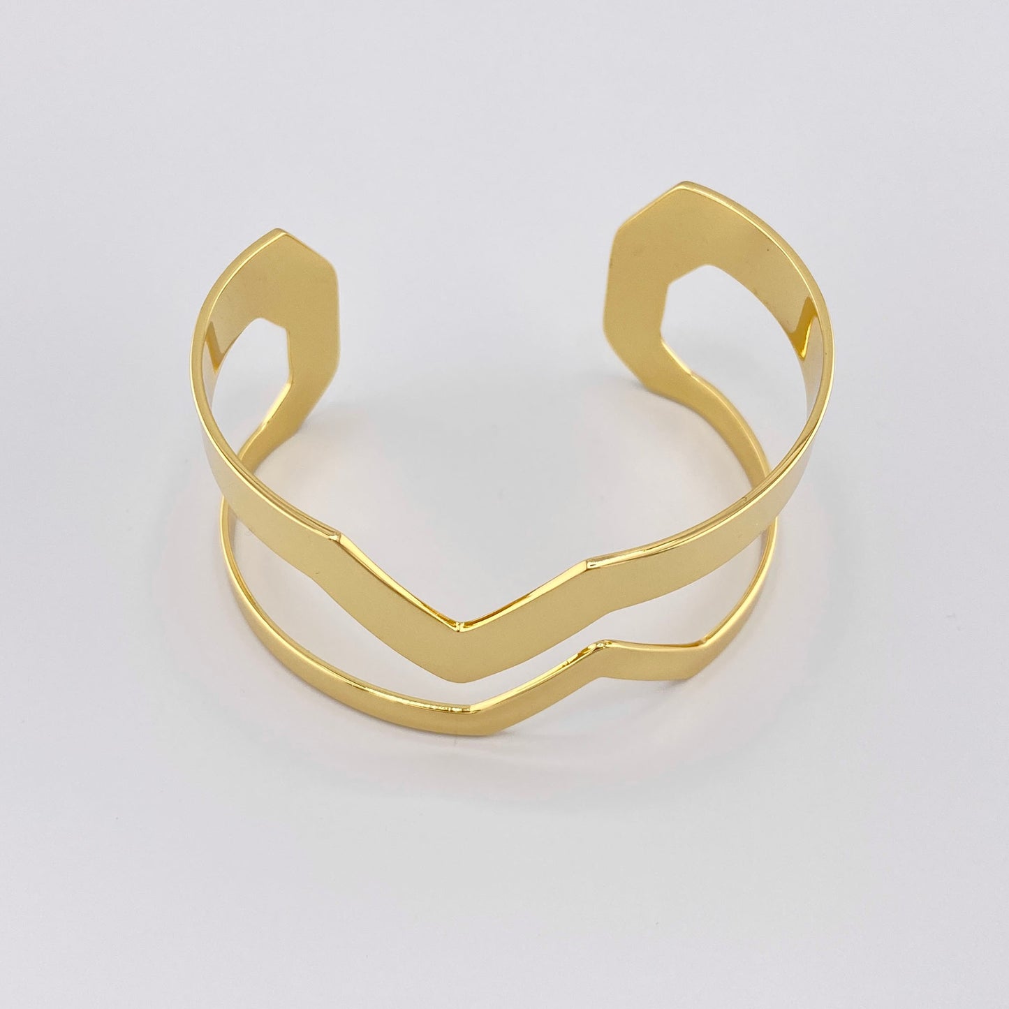 Brazalete abierto con diseño geométrico dorado, marca francesa IRL.