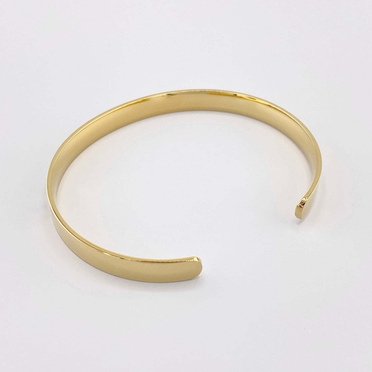 Gold-plated steel bracelet with a geometric black triangle pattern, French brand Ikita.