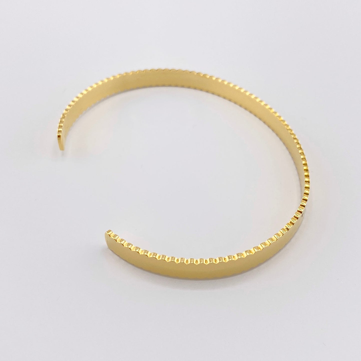 Gold-plated stainless steel bracelet with engraved inscriptions "LOVE", "AMOUR", "AMOR", French brand Ikita.