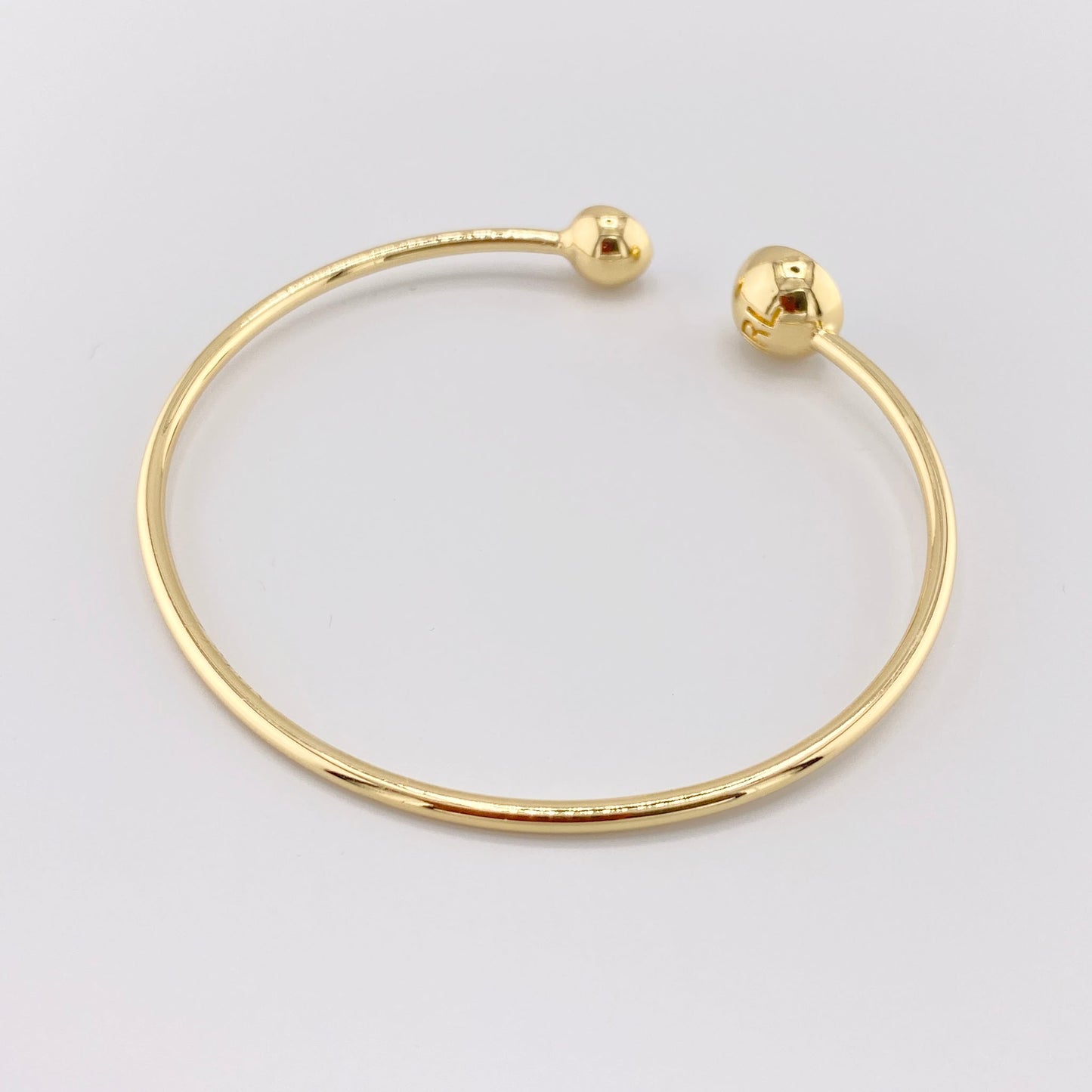 Brazalete rígido en tono dorado con cristales brillantes, marca francesa IRL.