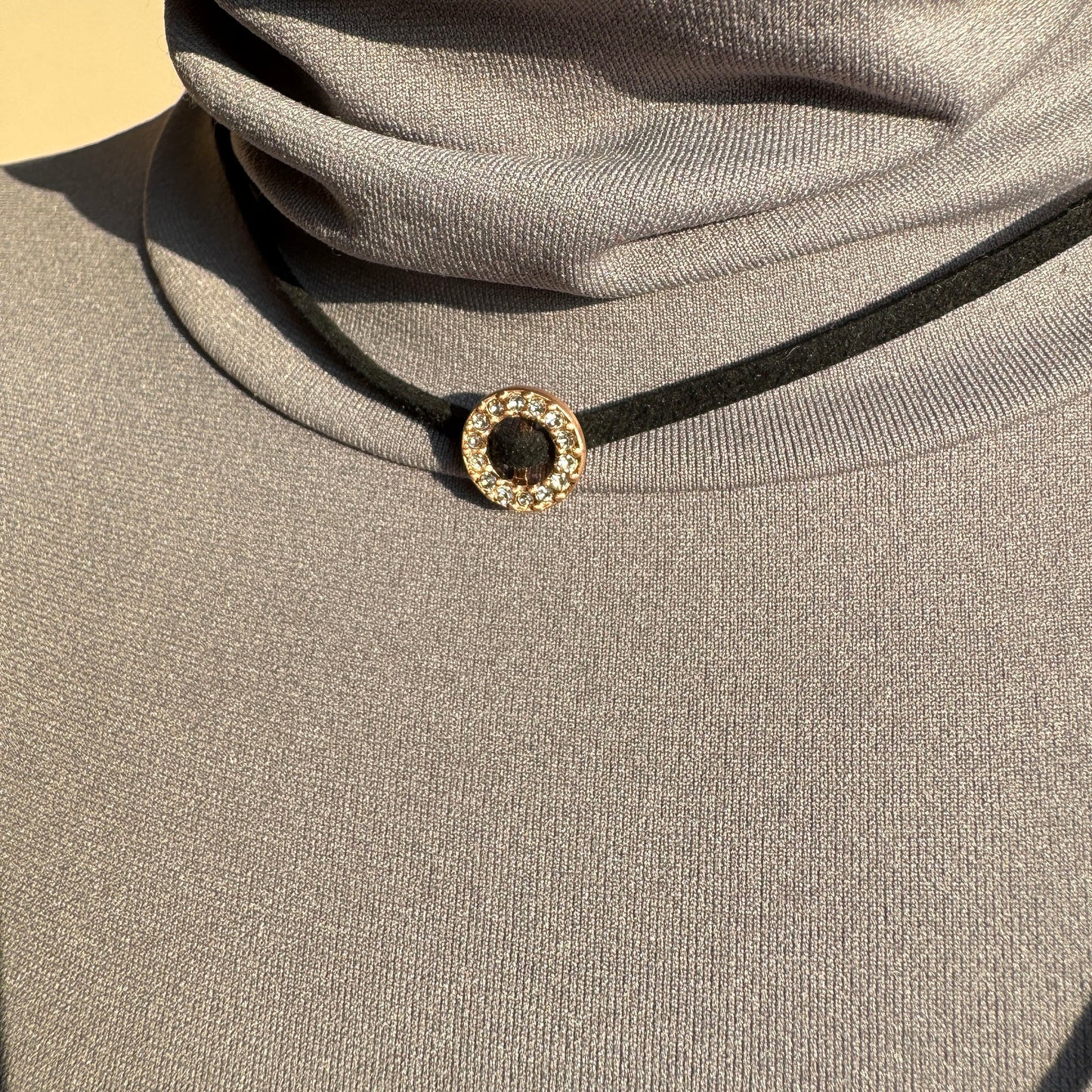 Adjustable black cord choker with gold ring and crystals by Pilgrim worn on neck