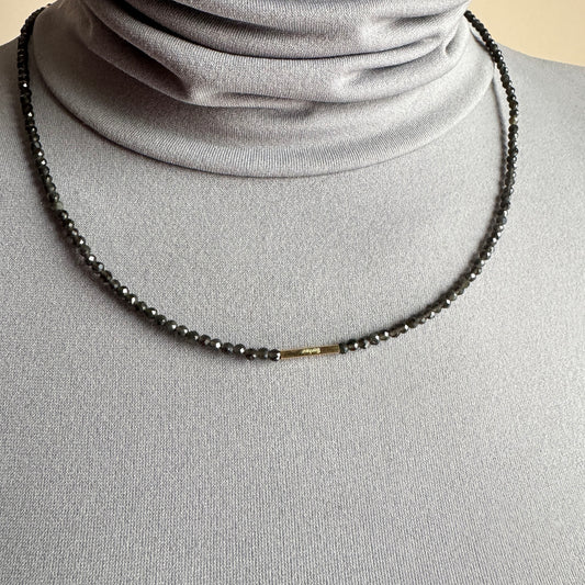 Agate necklace IRL worn close to the neck with dark faceted beads and gold accents