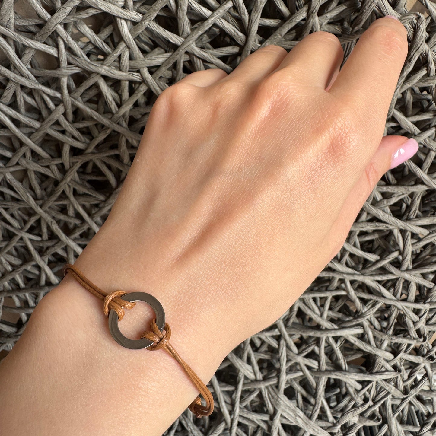 Bastille Baobab braided bracelet with caramel cord and steel circle shown on wrist