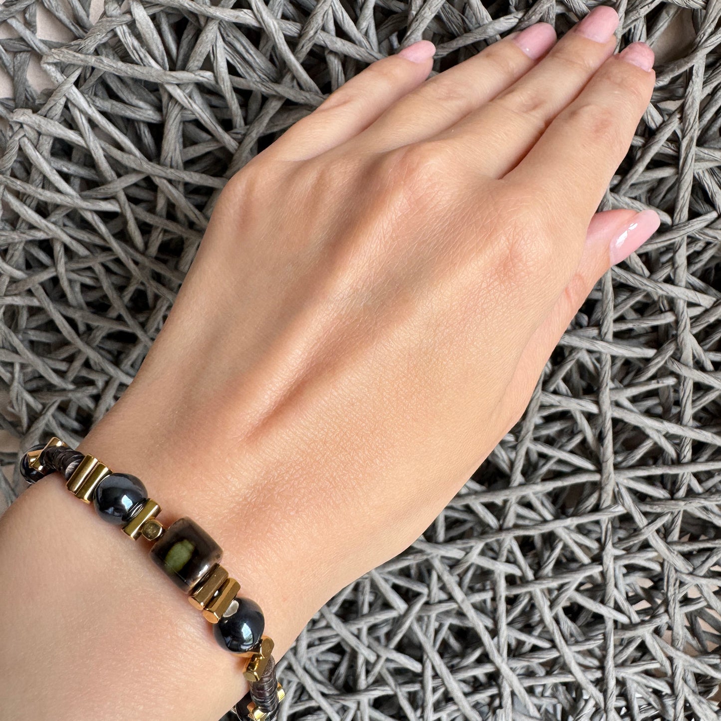 Bracelet with black ceramic stones and gold accents worn on wrist