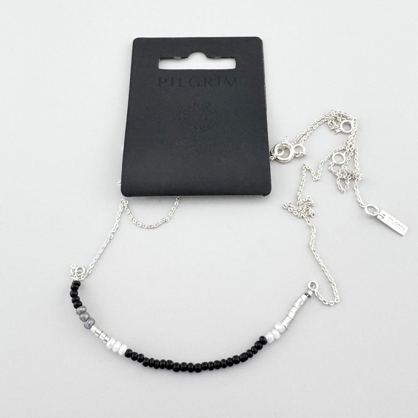 Collar minimalista con cuentas negras, blancas y grises y cadena brillante