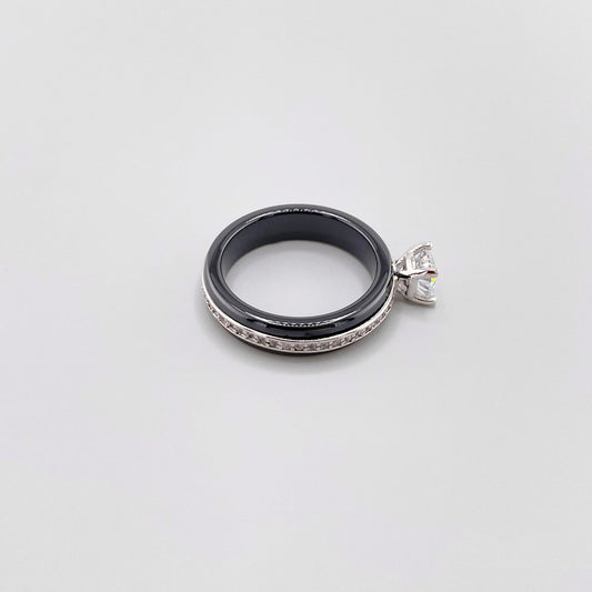 Black ceramic ring by Luxury Avenue shown at an angle with a round crystal and silver-tone edge