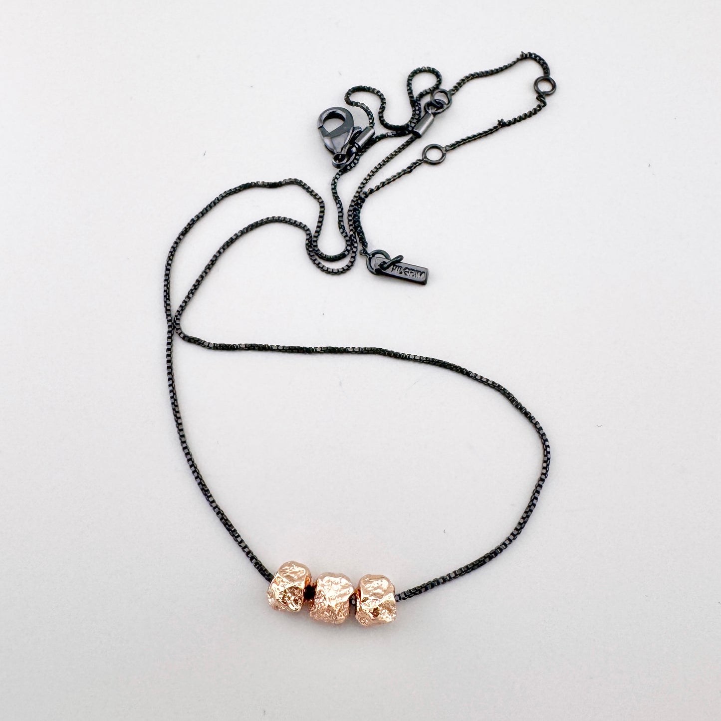 Collier noir avec perles en or rose et design épuré Pilgrim