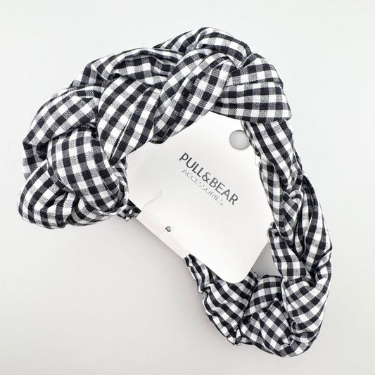 Black and white gingham Pull&Bear headband folded to show its braided shape and branded tag