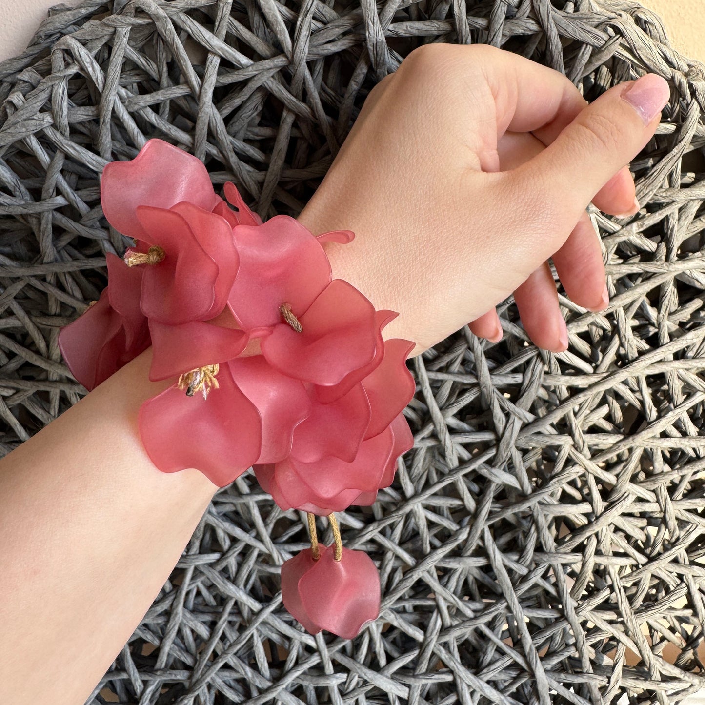 Romantisches Armband aus rosa Blütenblättern am Handgelenk