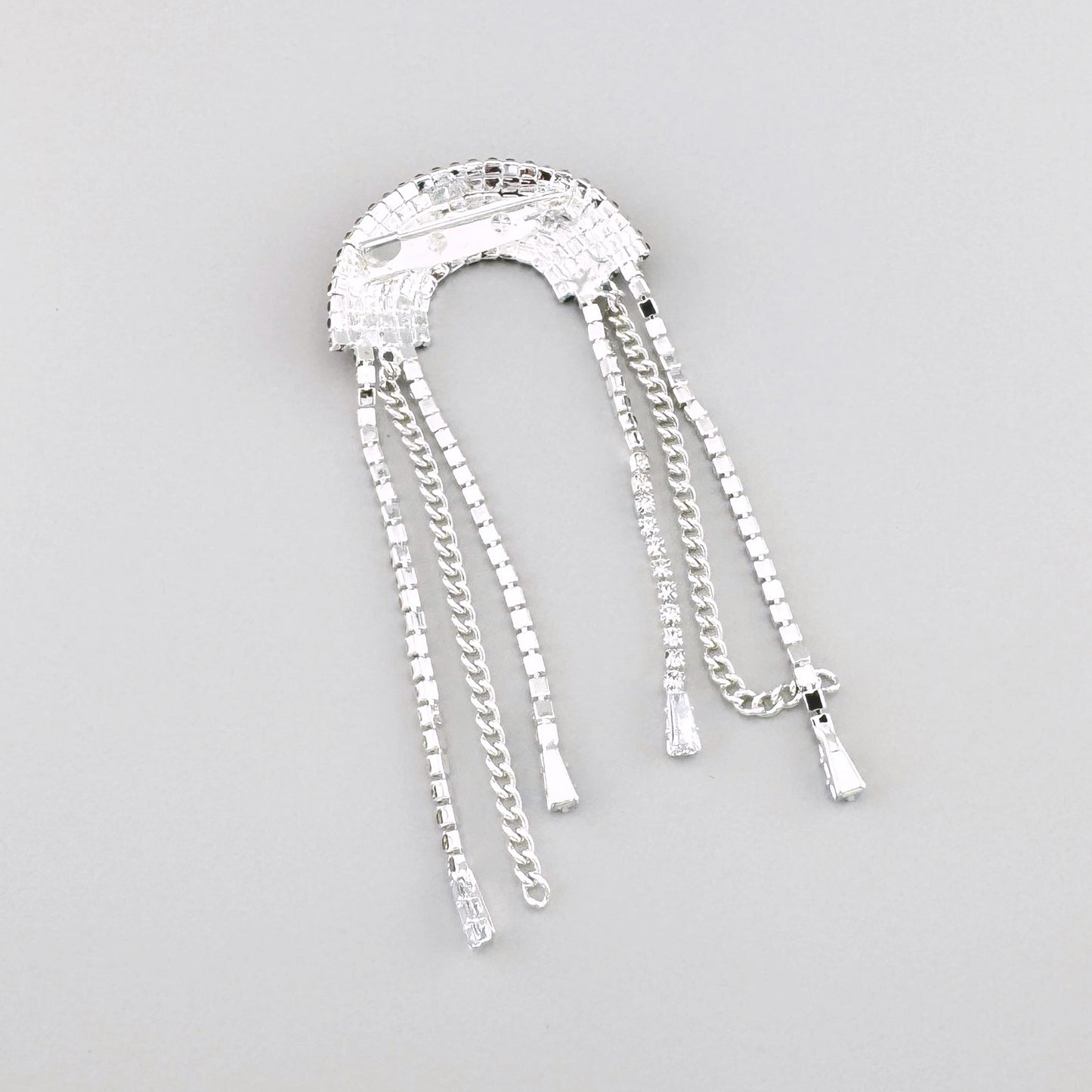 Broche rainbow Maravillas con cristales y cadenas colgantes en tono plateado