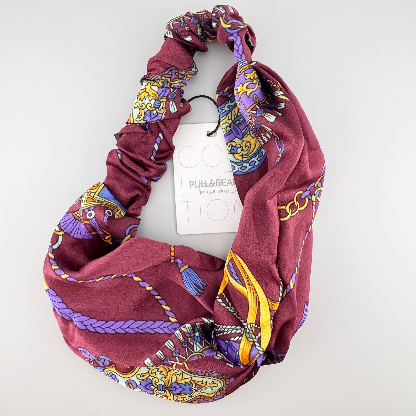 Burgundy Pull&Bear headband folded to show its chain print, baroque details, and satin sheen
