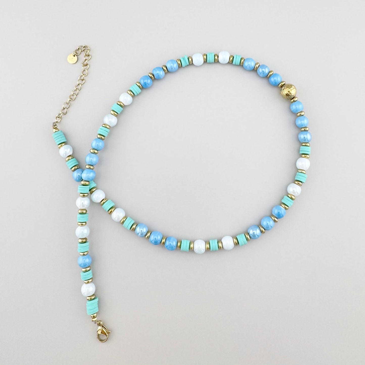 Halskette mit perlenartigen Keramikelementen in Mint und Gold, Marke Ikita.