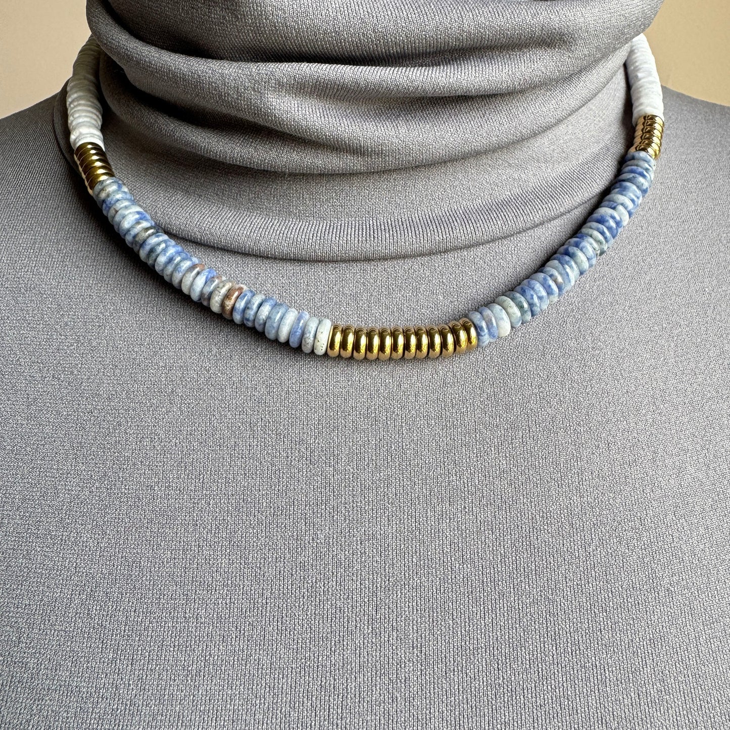 Gray-blue sodalite necklace with matte white discs and gold accents, minimalist style by Ikita.