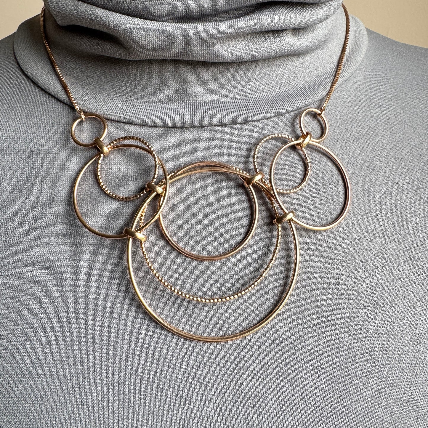 Gold-tone circle chain necklace worn on the neck with adjustable length