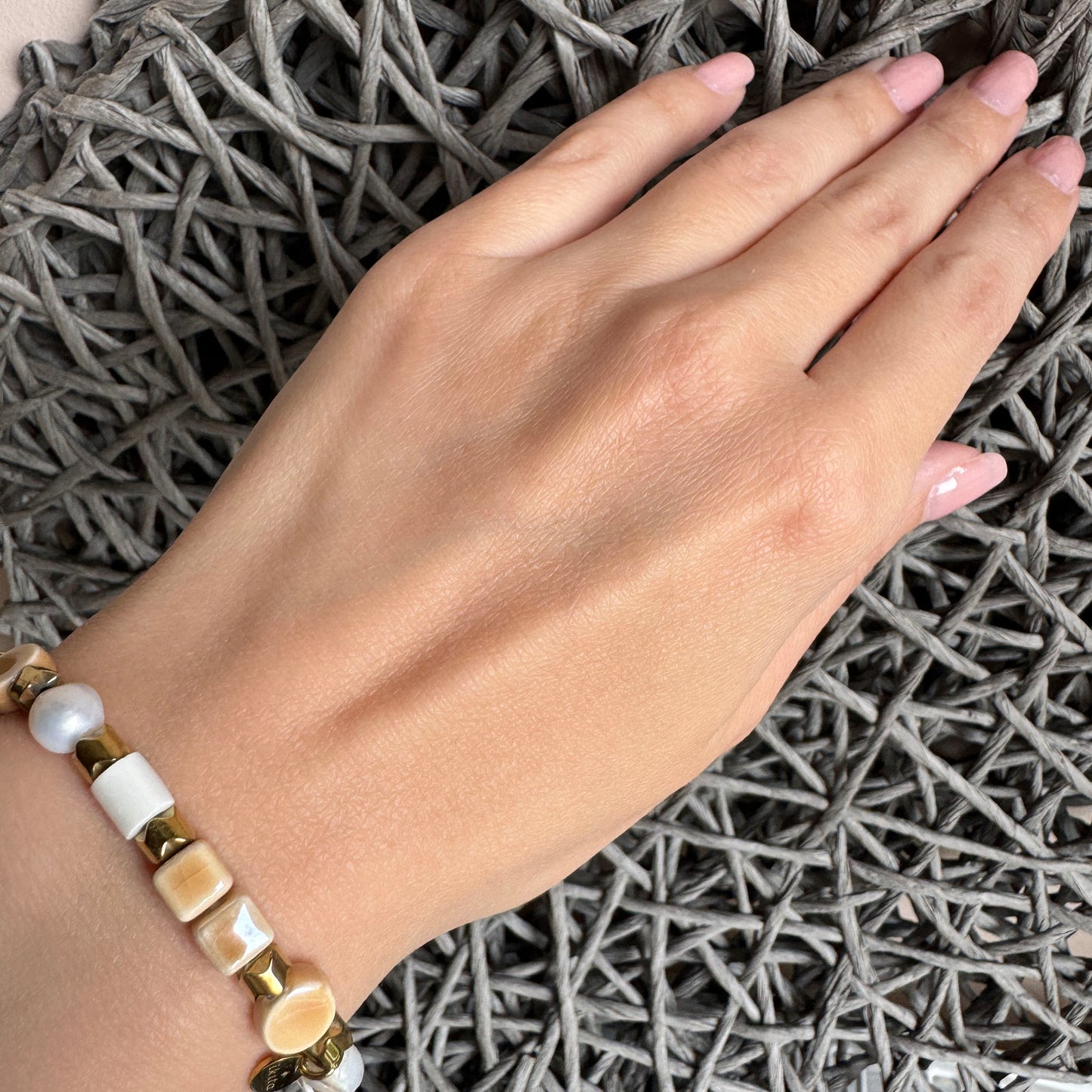 Cream ceramic and pearl bracelet with shiny gold accents, delicate organic design by Ikita.