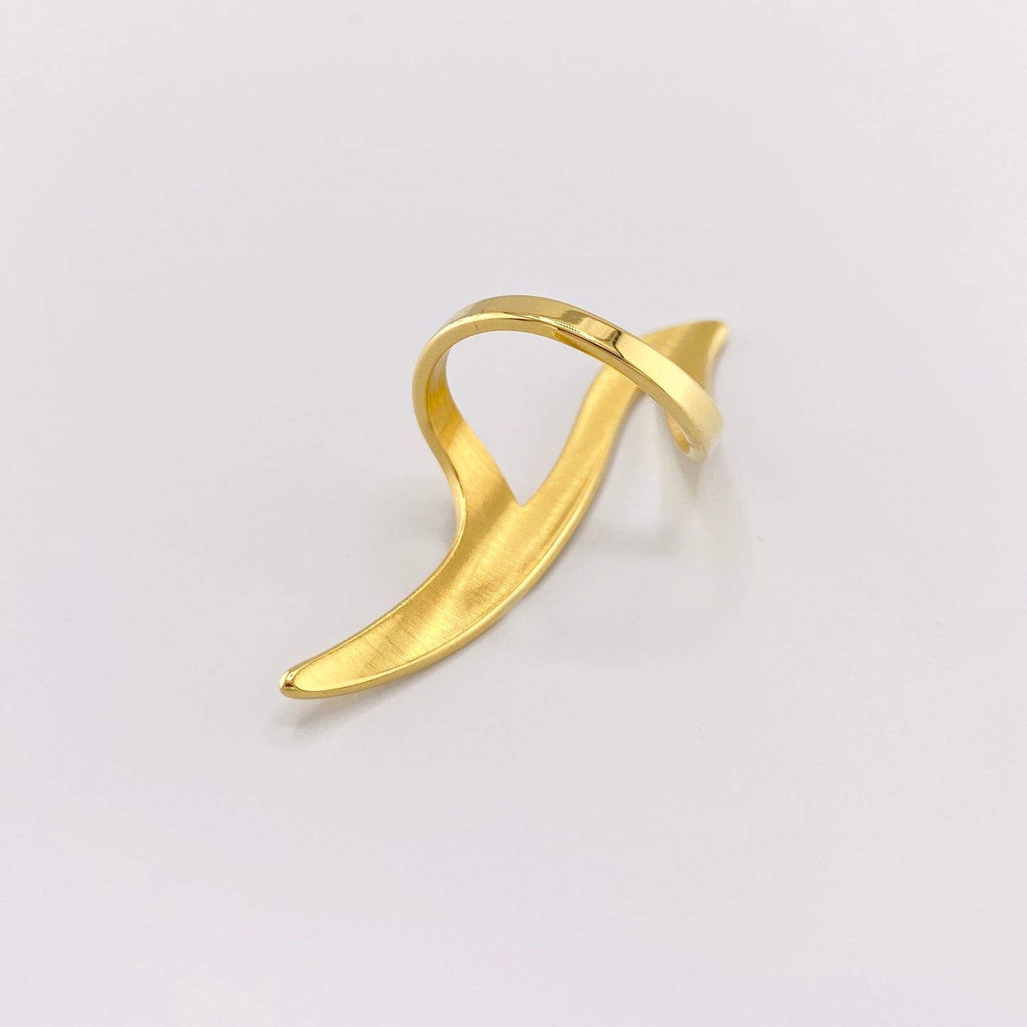 Gebogener Ring in Goldoptik mit moderner, abstrakter Wellenform aus Seitenansicht