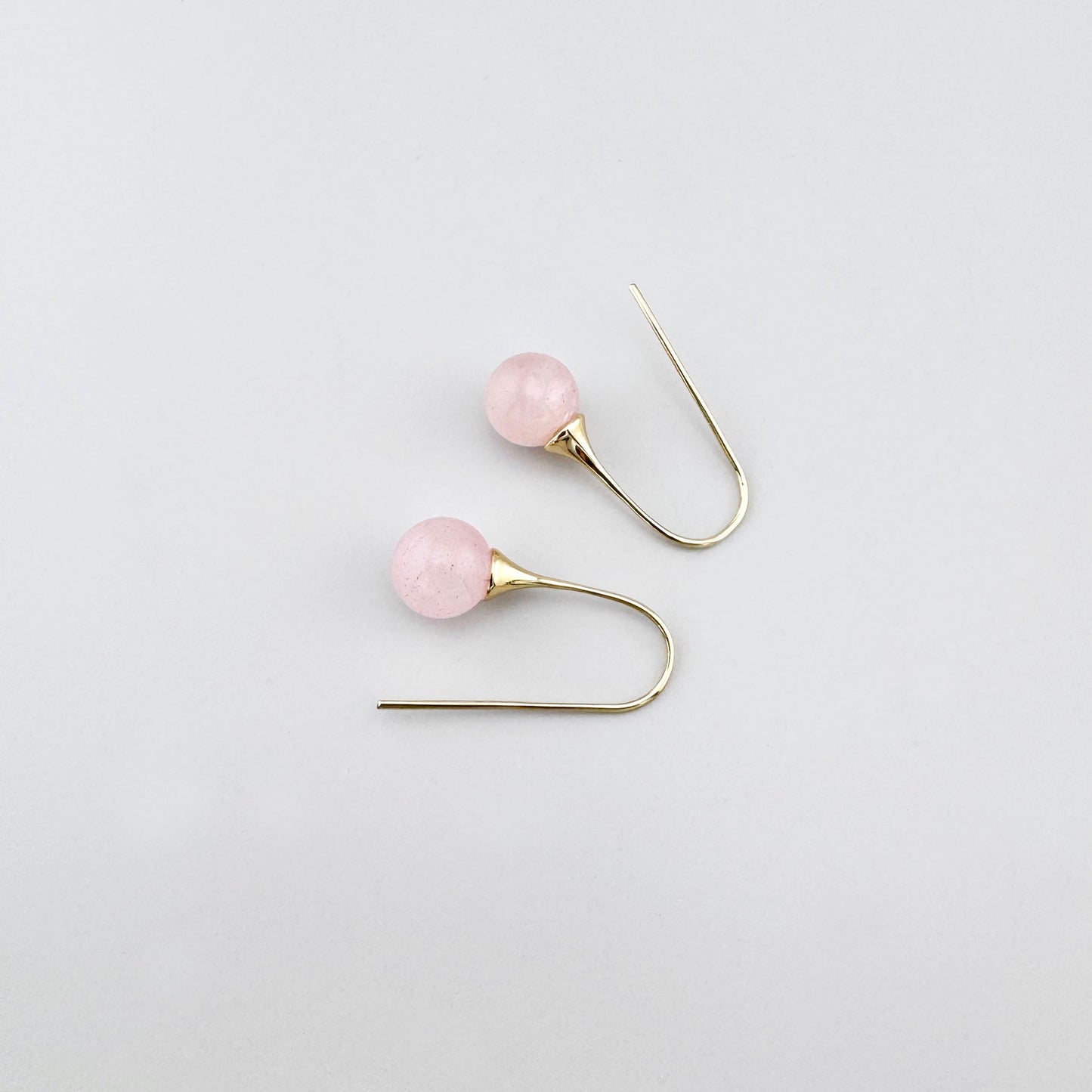 Pendientes delicados con cuarzo rosa y gancho dorado de forma clásica