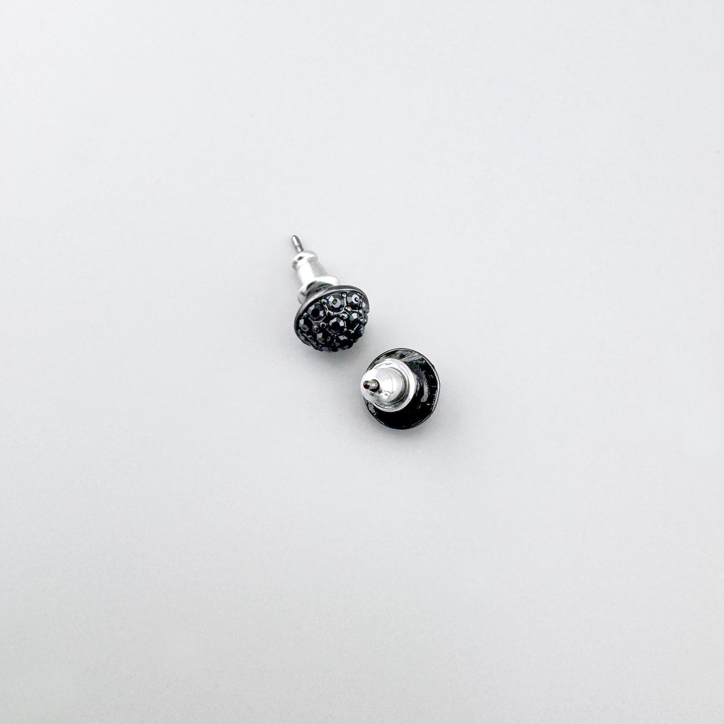 Ohrstecker mit zwei schwarzen Kristallen nebeneinander auf weißem Hintergrund