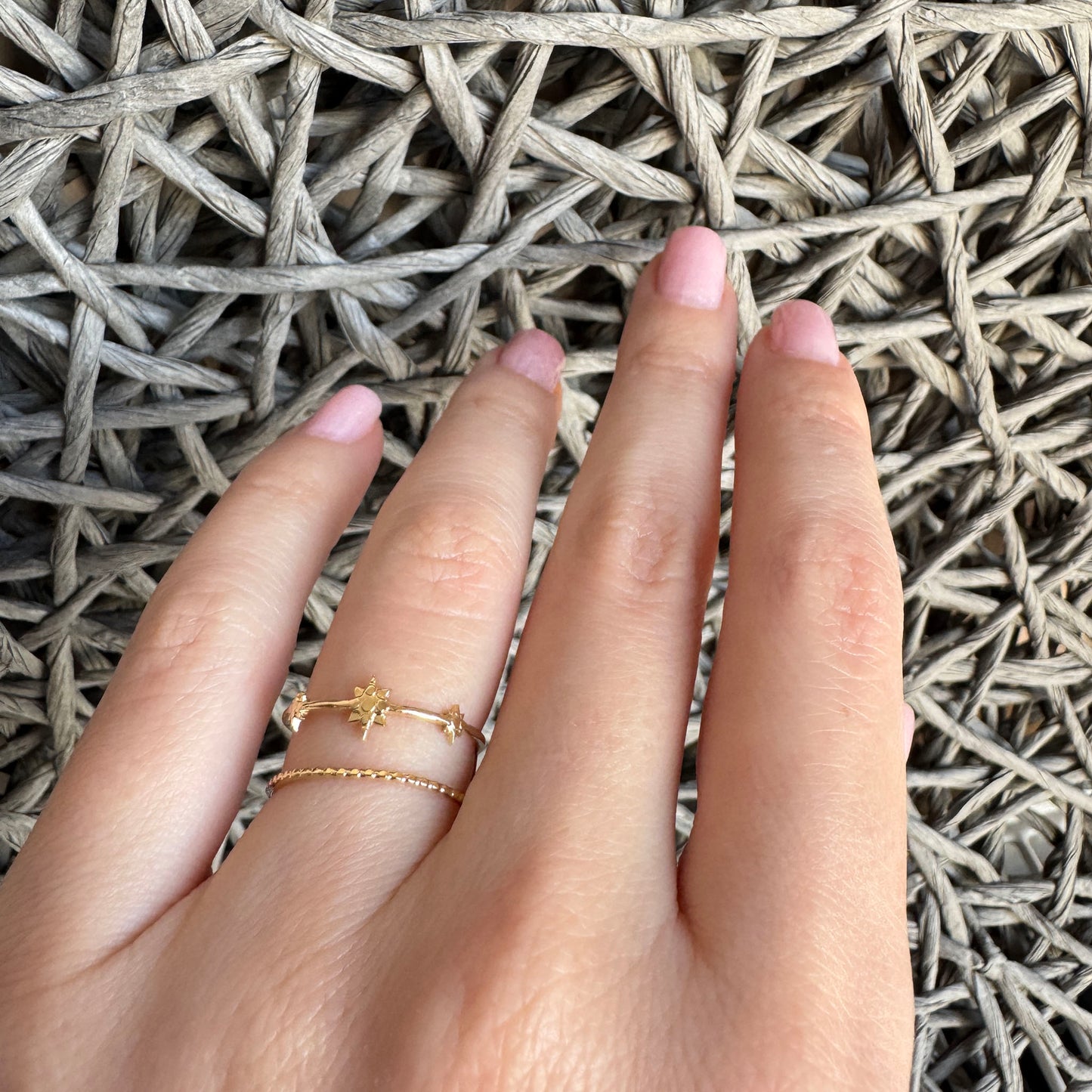 Double gold IRL ring with star detail worn delicately on hand