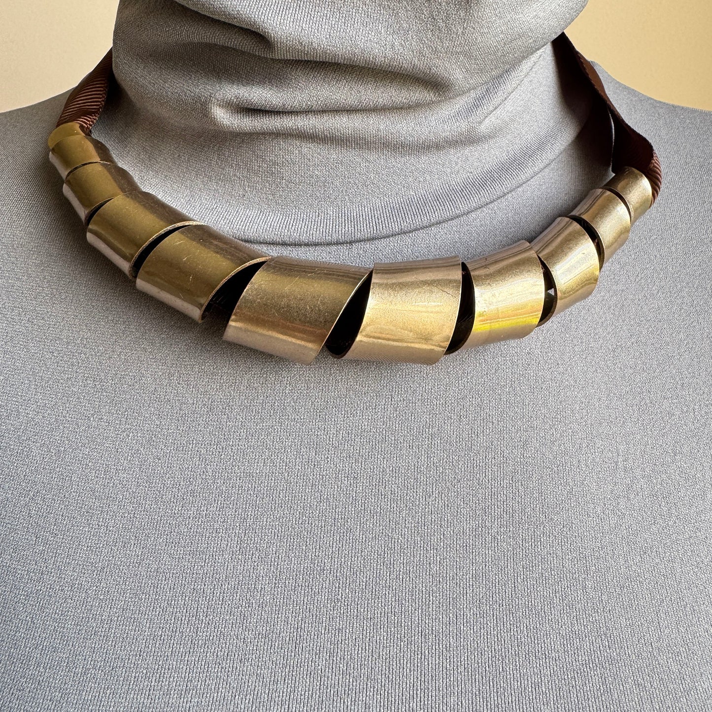 Modern metal necklace with rose gold finish on wide ribbon
