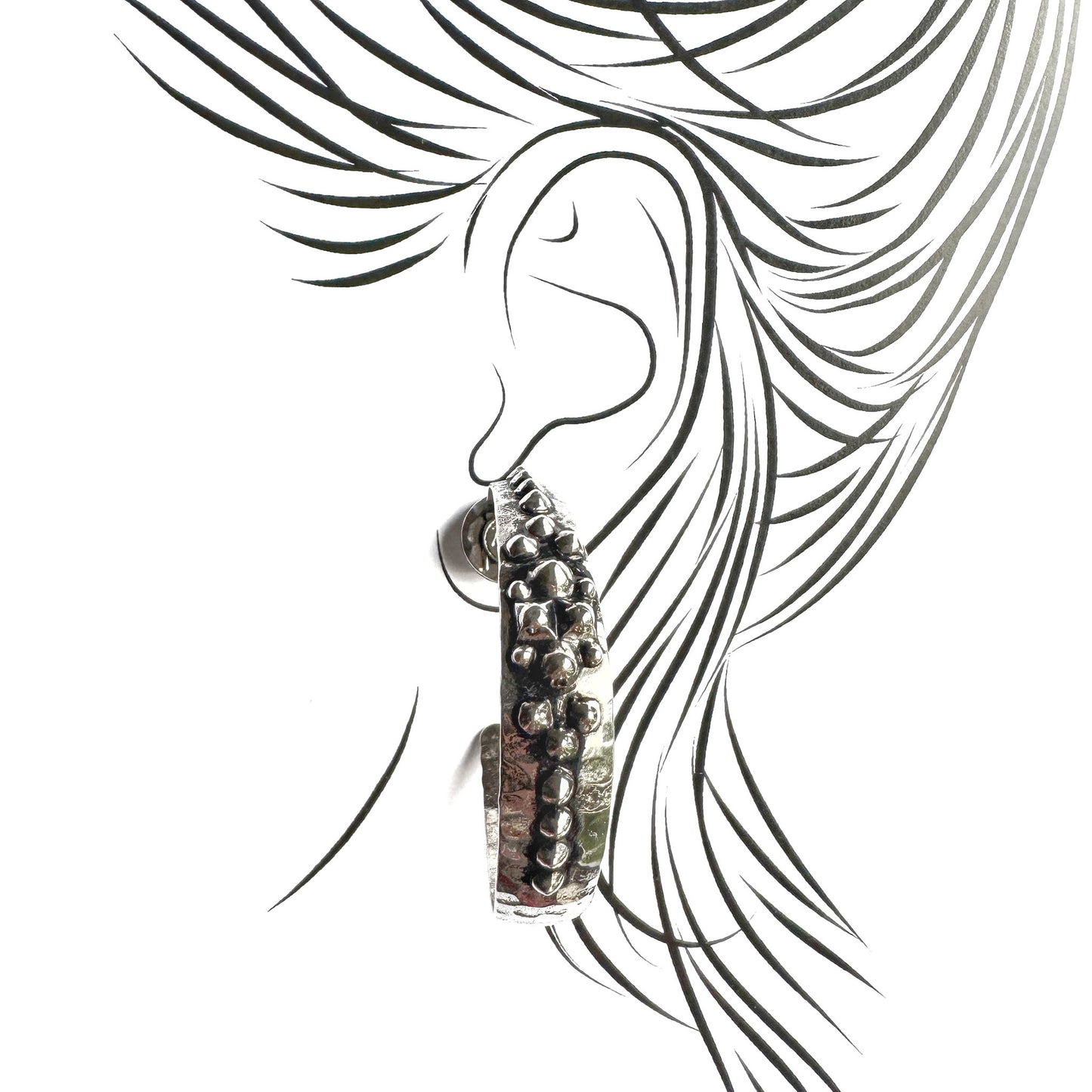 Ethnic-inspired silver hoop earrings with hammered surface and unique detailing