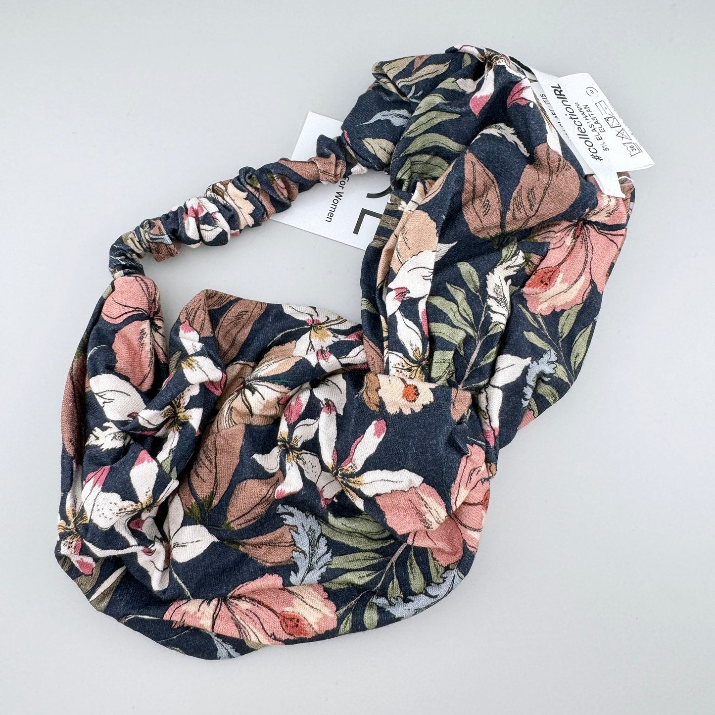 Diadema IRL con estampado floral y etiqueta visible en tejido elástico