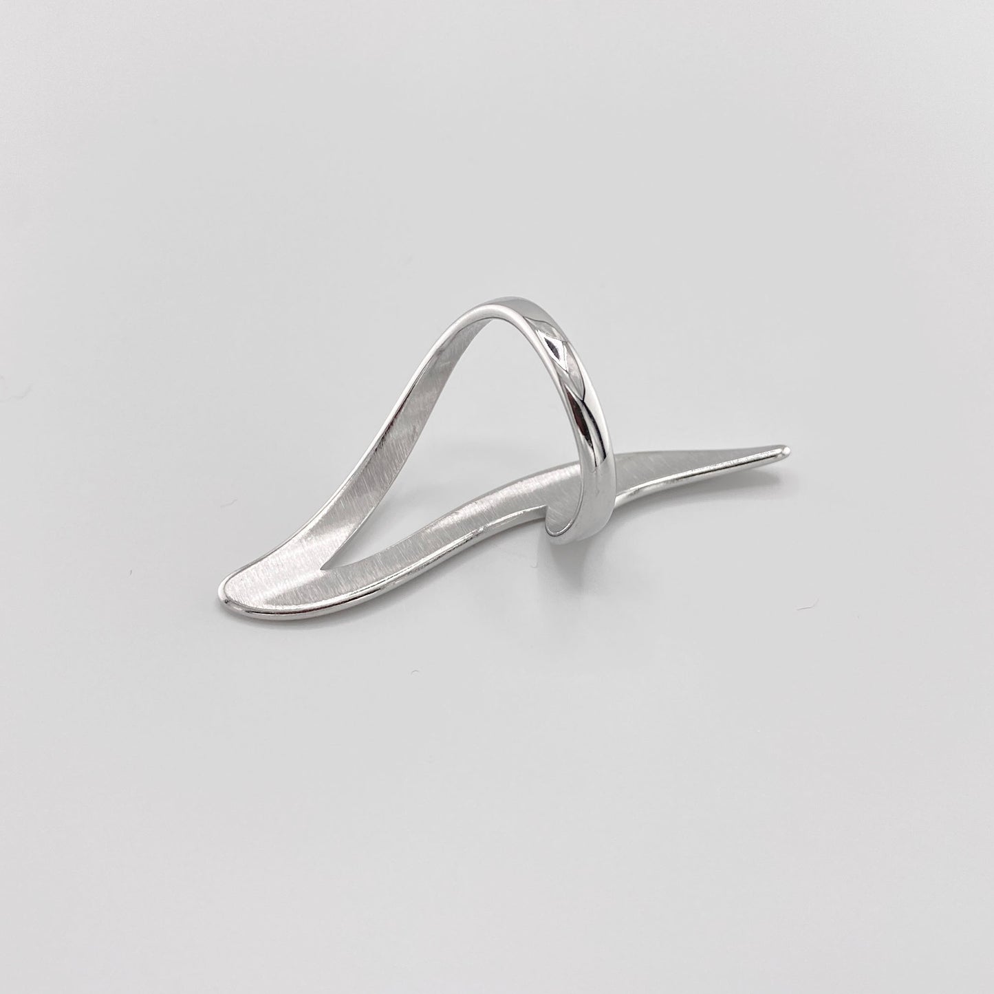 Bague argentée en forme de vague fluide avec finition miroir moderne