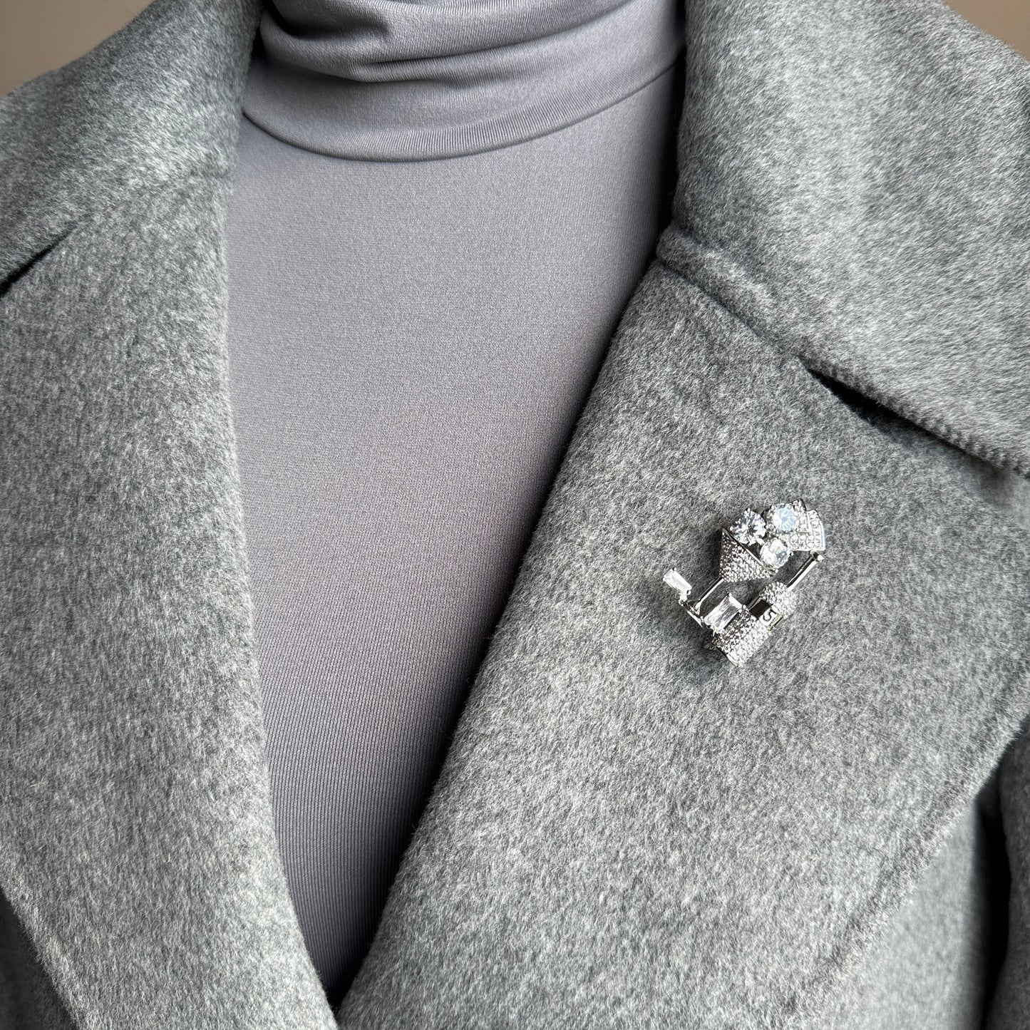 Sparkling cocktail glass brooch worn on coat, ideal for parties and holiday looks