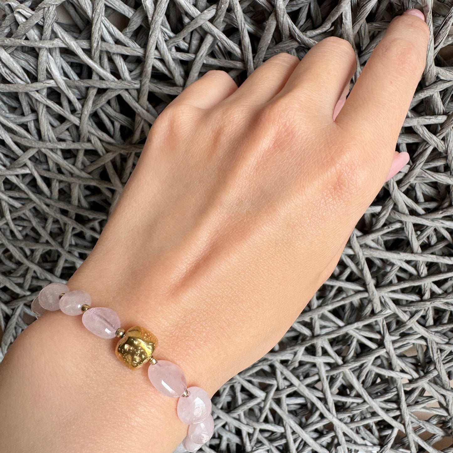 Polished rose quartz bracelet with golden artistic accent