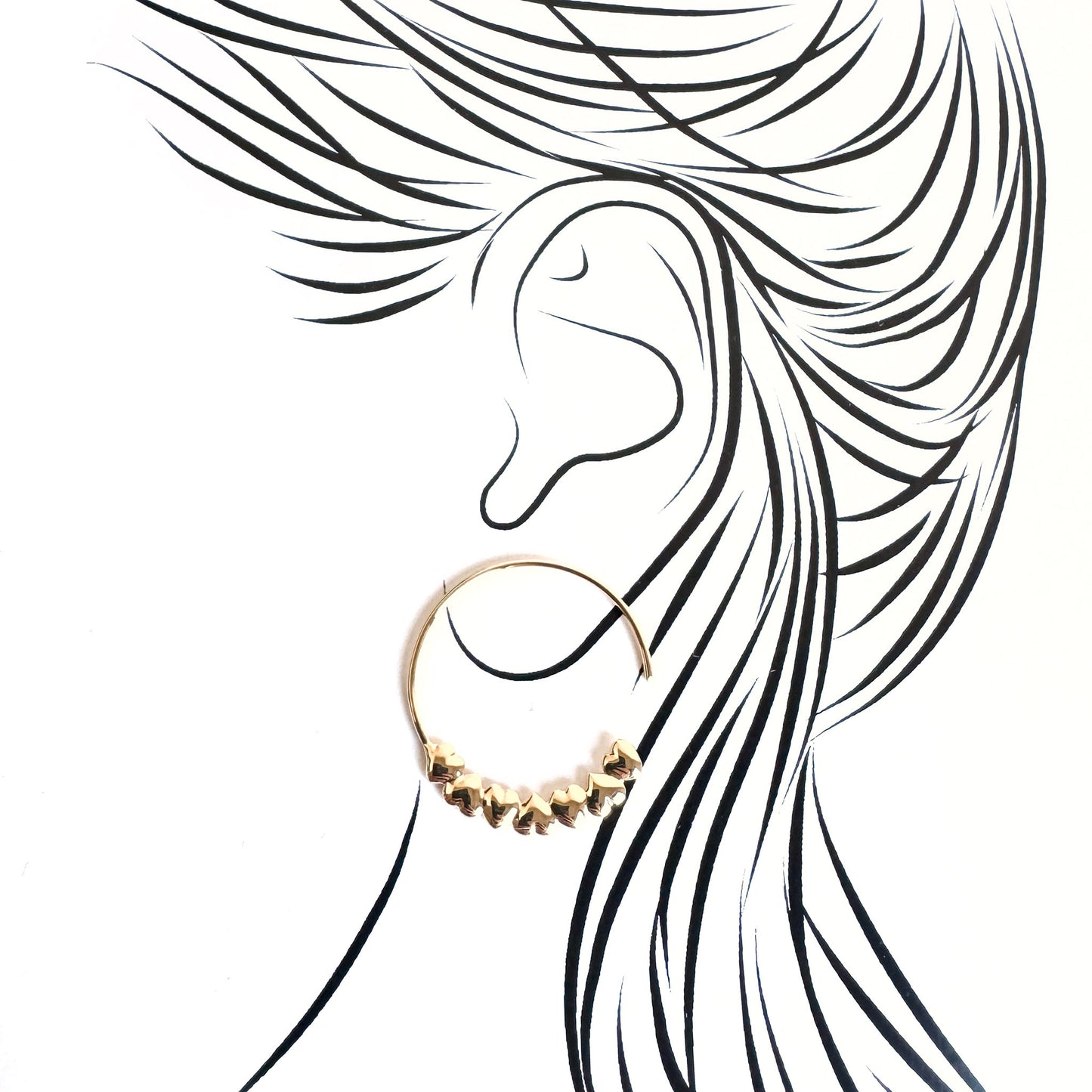 Delicate gold hoop earrings with heart details illustrated on an ear silhouette