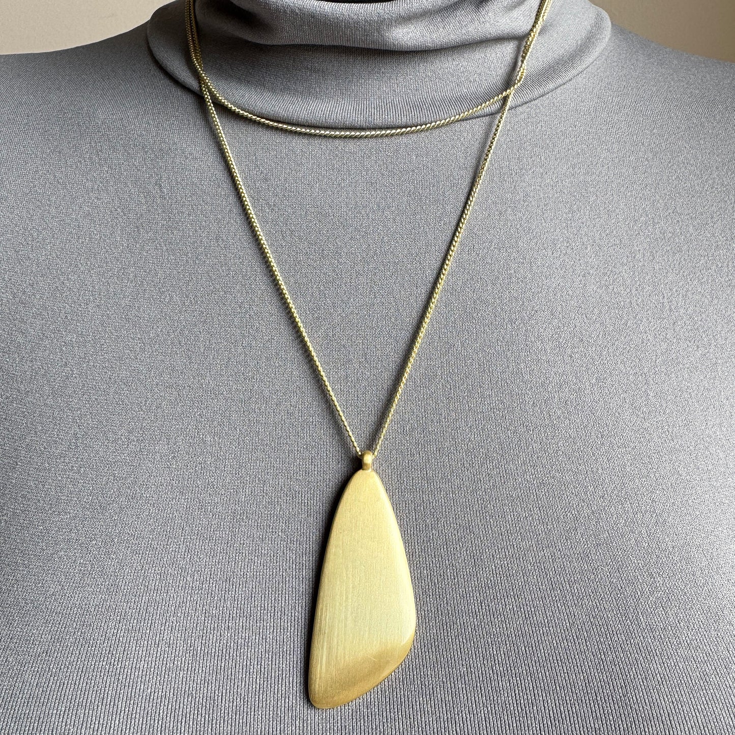 Gold Pilgrim necklace with sculptural large pendant worn on neck