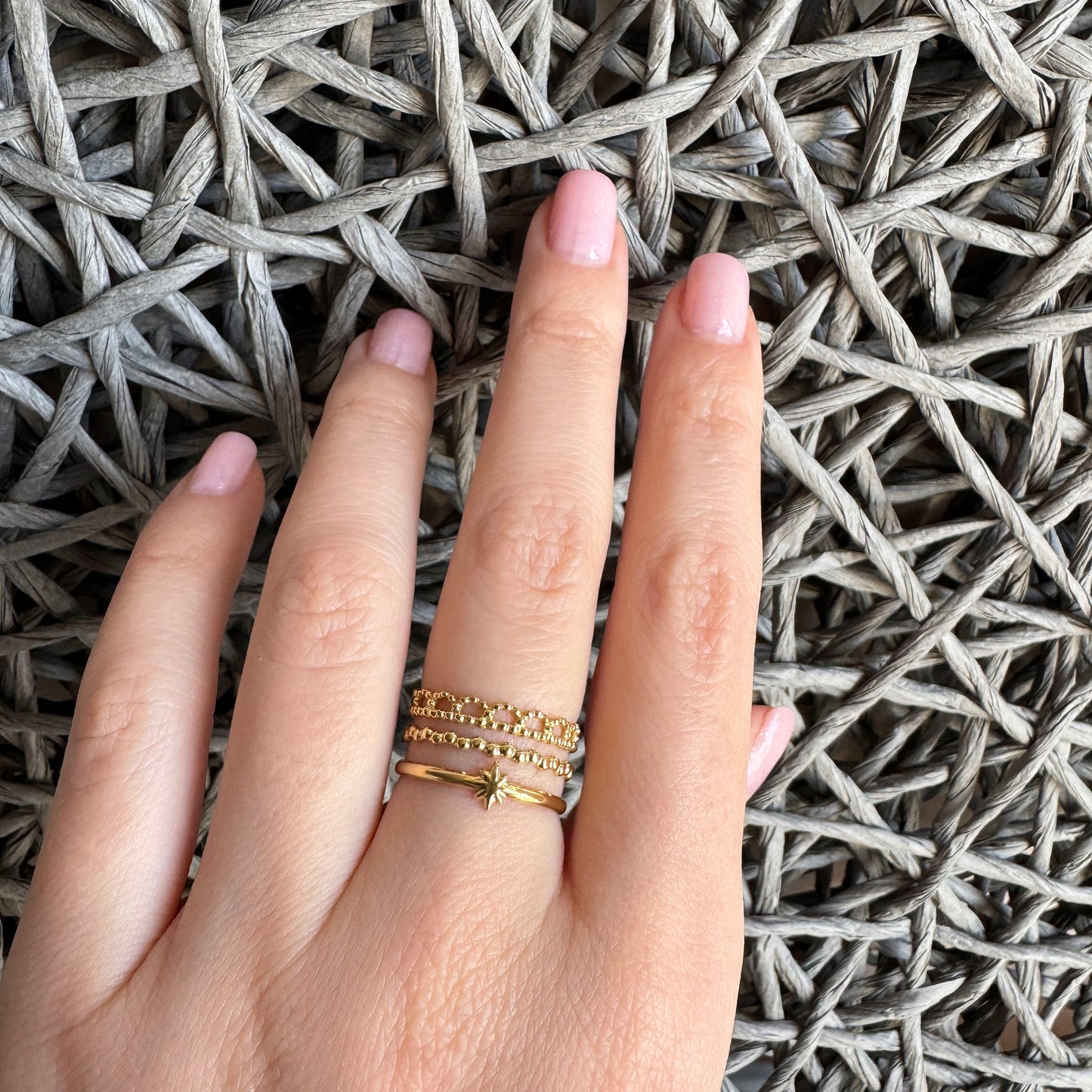 Bague triple IRL dorée avec motif étoile vue de près sur la main