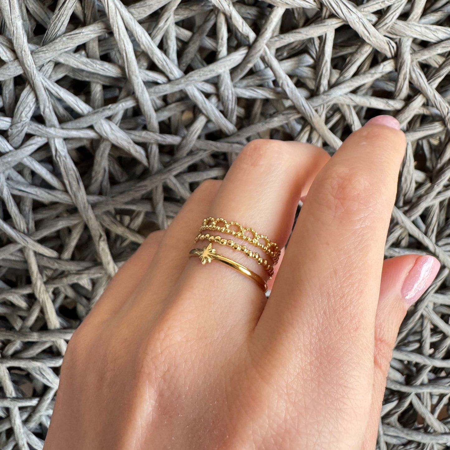 Triple gold IRL ring with star motif worn elegantly on hand