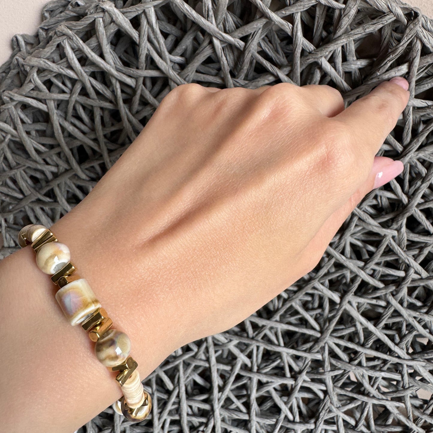 Beige ceramic bracelet with gold geometric accents, handcrafted feel by Ikita.