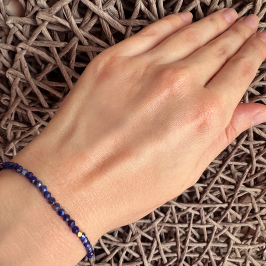 Lapis lazuli bracelet IRL worn on the wrist with deep blue faceted beads