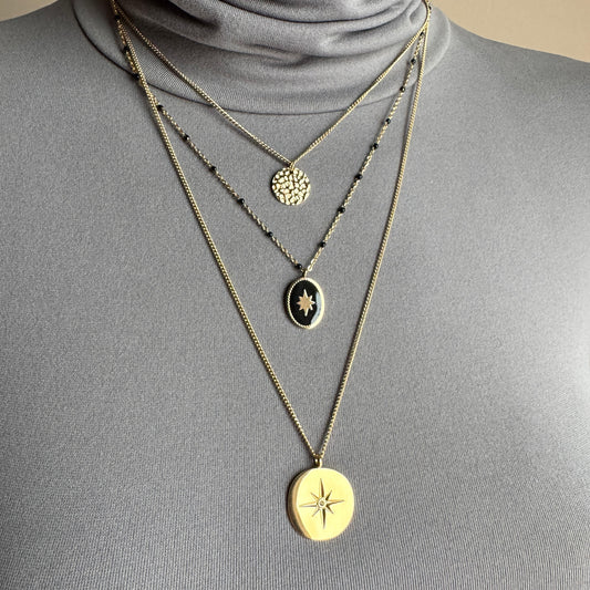 Layered medallion necklace IRL worn on the neck with black beads and gold-tone pendants