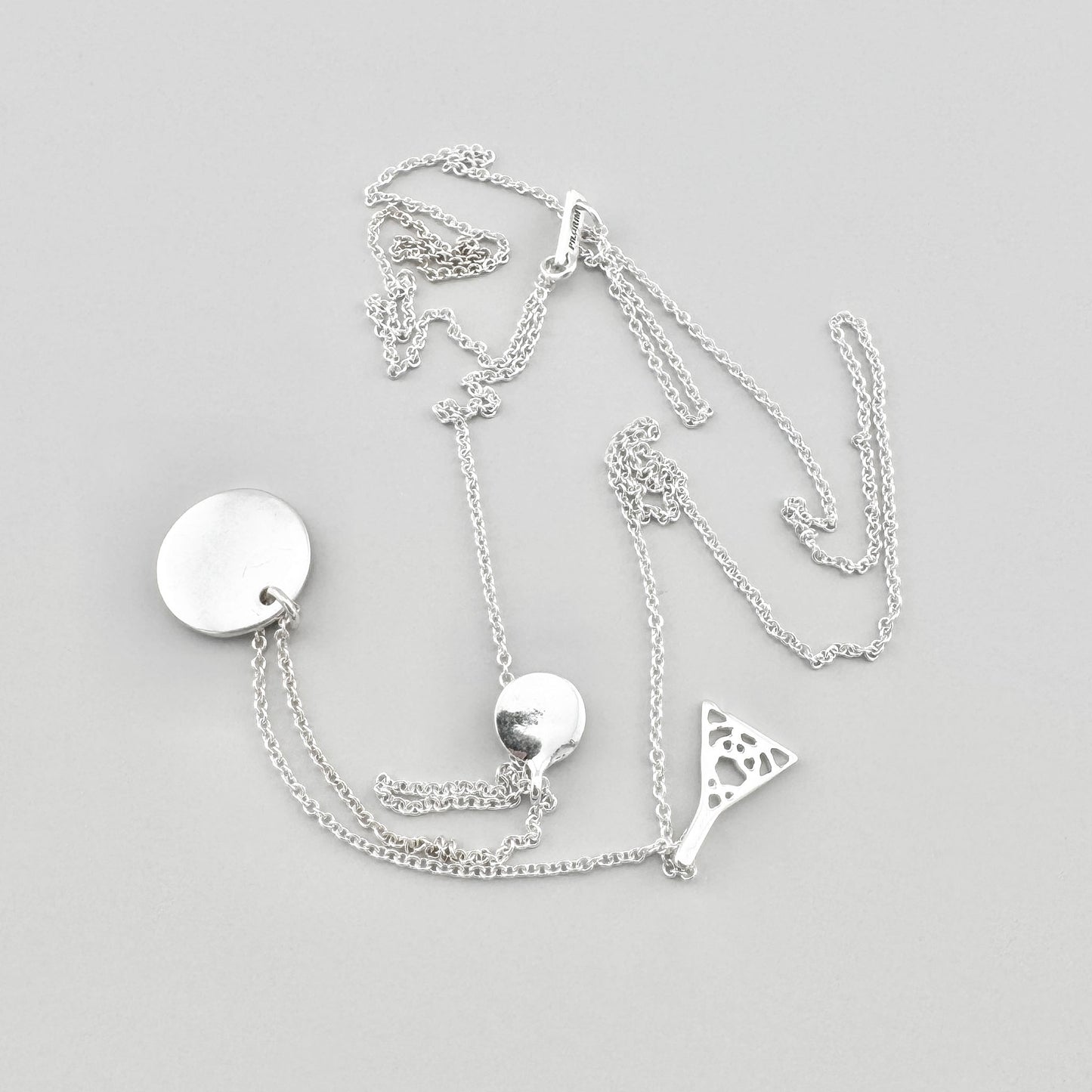 Pilgrim necklace with three pendants arranged on a light background with branded tag