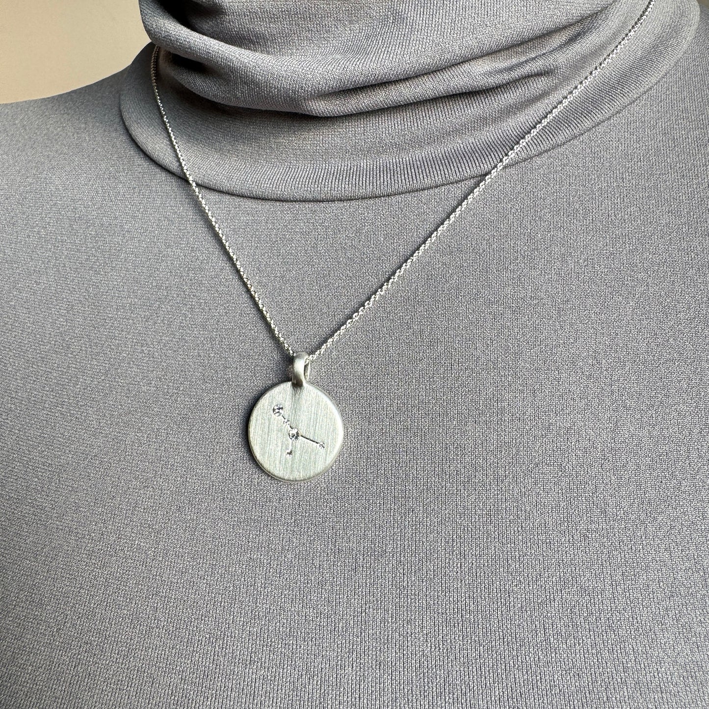 Pilgrim silver necklace with engraved star constellation medallion worn on neck