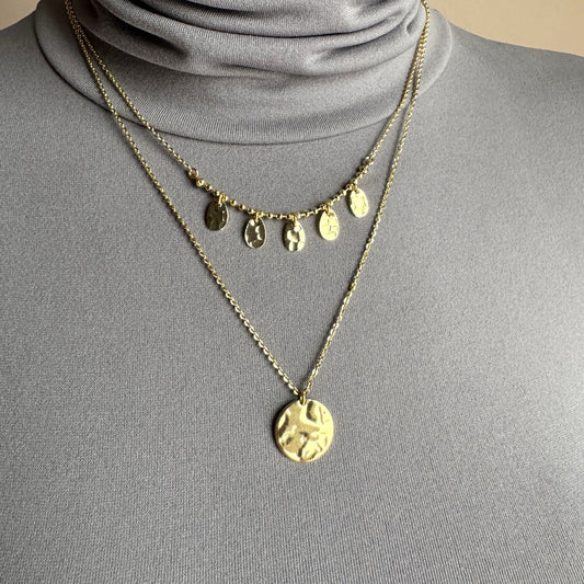 Gold medallion necklace IRL worn layered on the neck with hammered pendants
