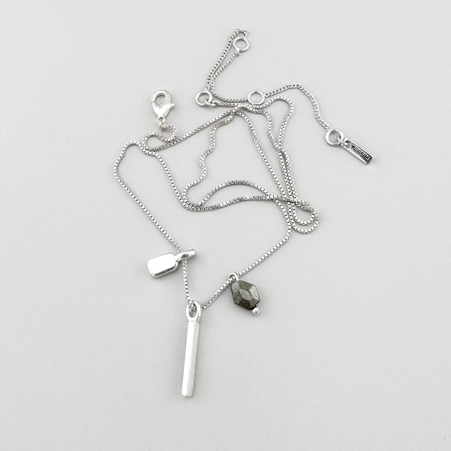 Collier argenté minimaliste avec hématite et pendentifs subtils