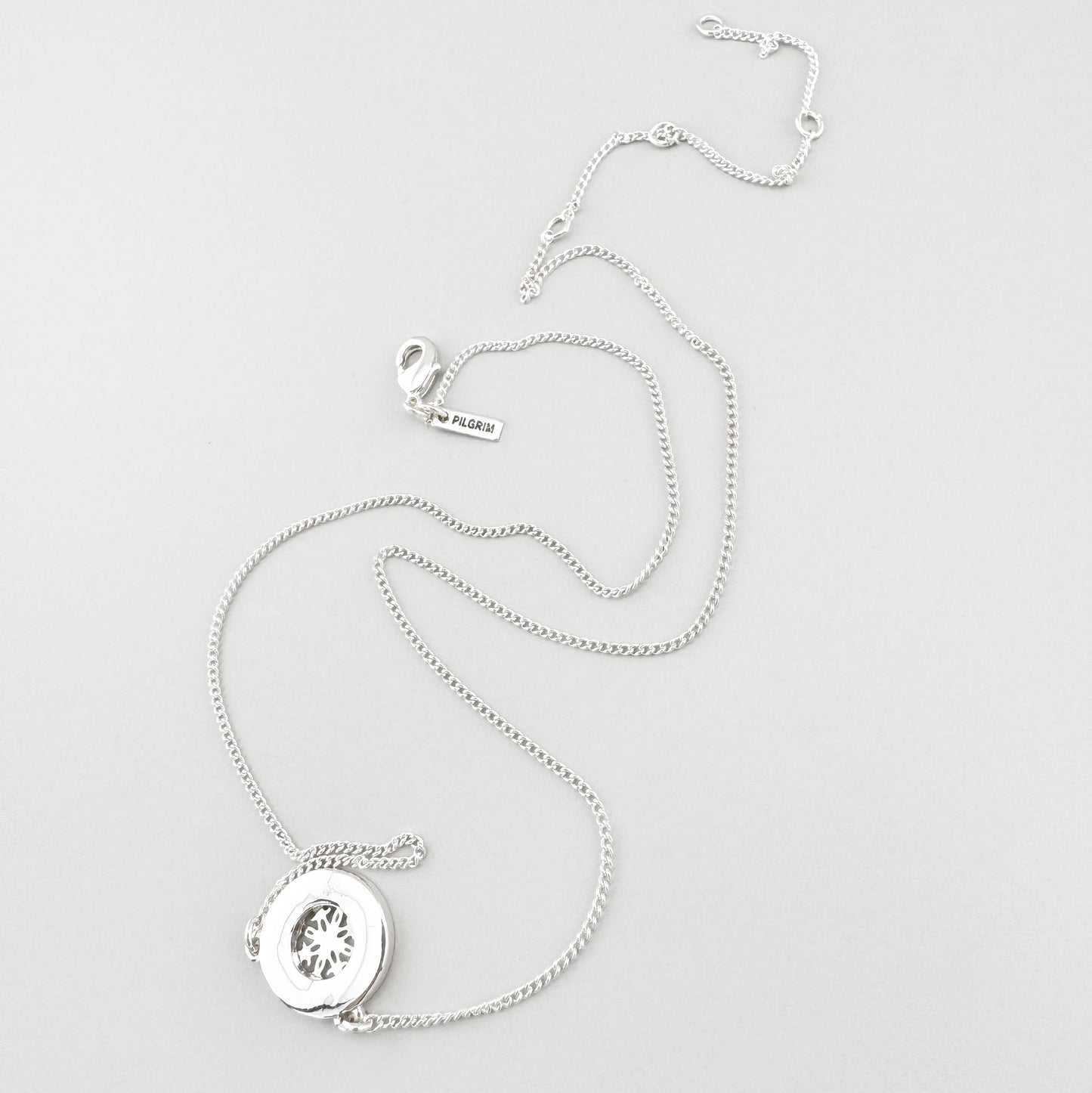 Collier argenté délicat avec médaillon ajouré et cristaux brillants
