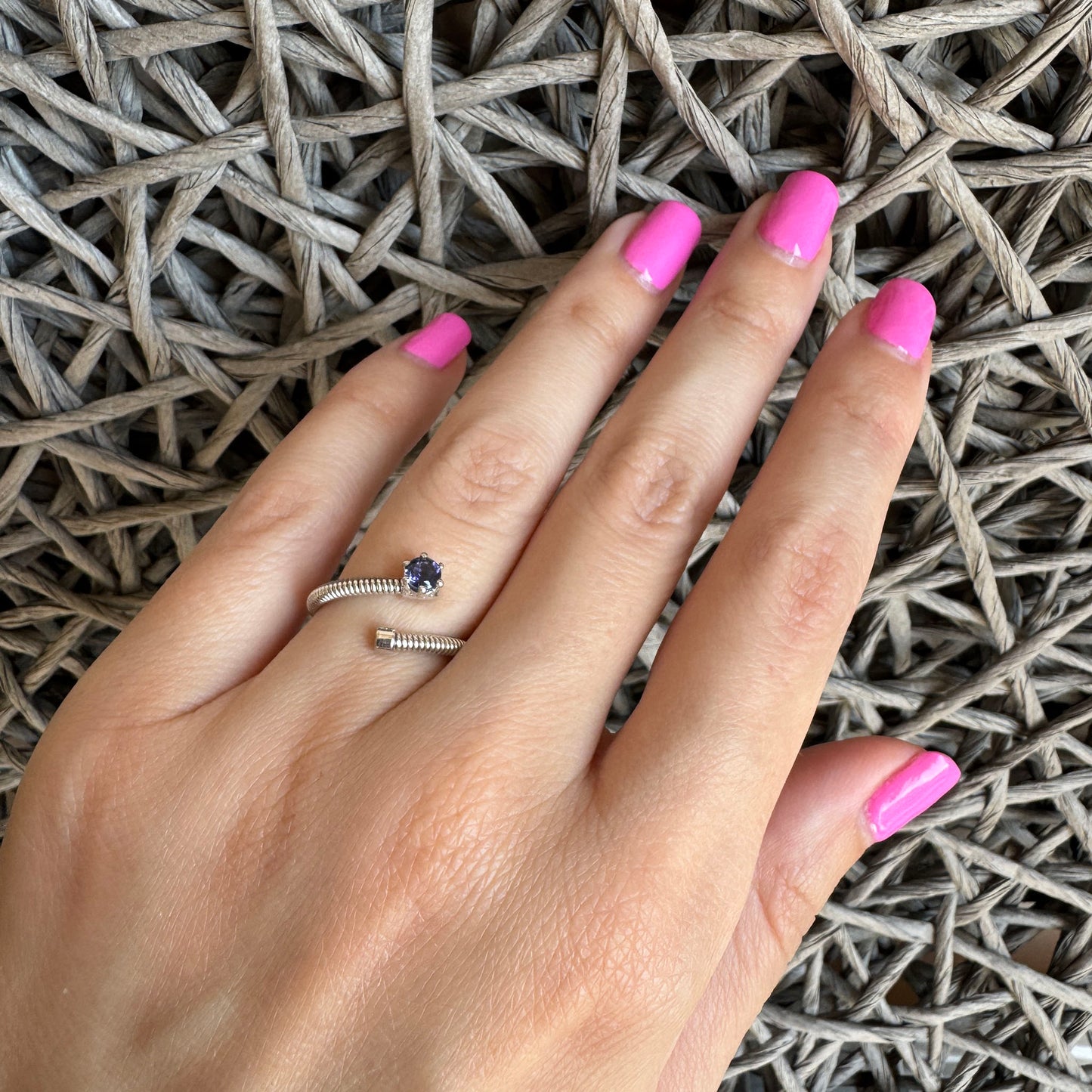 Minimalist silver spiral ring with deep blue iolite worn on hand