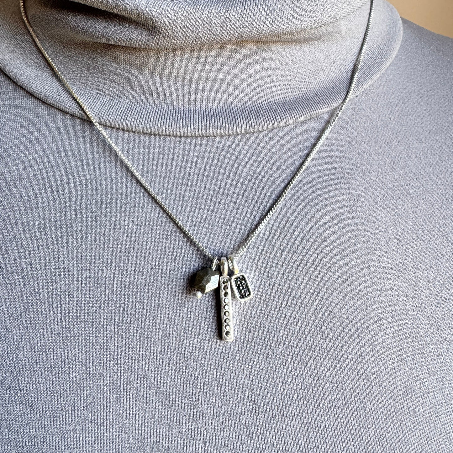 Sleek hematite necklace with delicate charms and adjustable chain